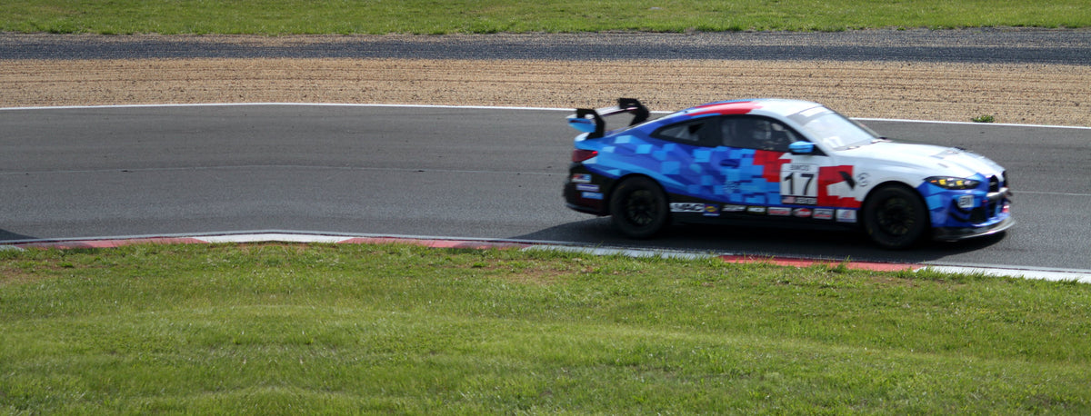 BMW M4 race car #17 at speed on track at Summit Point Motorsports Park